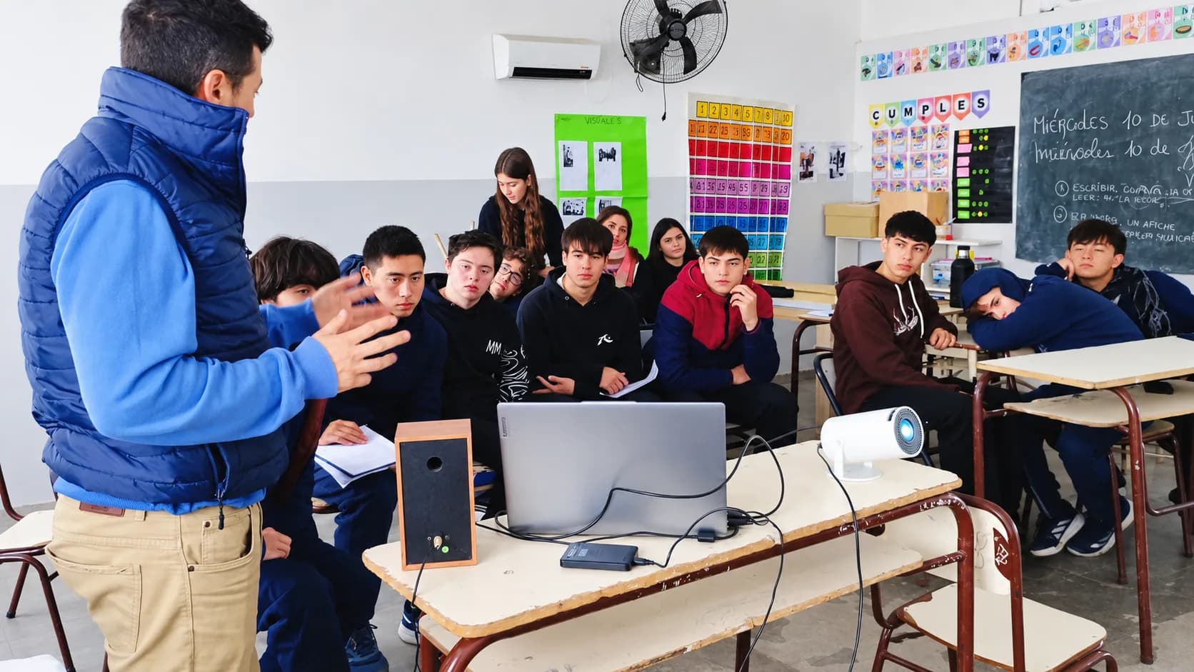 Una charla con proyector en el aula, con los estudiantes escuchando